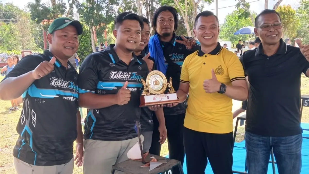 Kepala Polsek Telawang Ipda Fadheli Rachman (kemeja kuning) membagikan hadiah kepada juara lomba kicau mania di Kecamatan Telawang, Minggu (19/7). (KAPOLSEK TELAWANG/RADAR SAMPIT)
