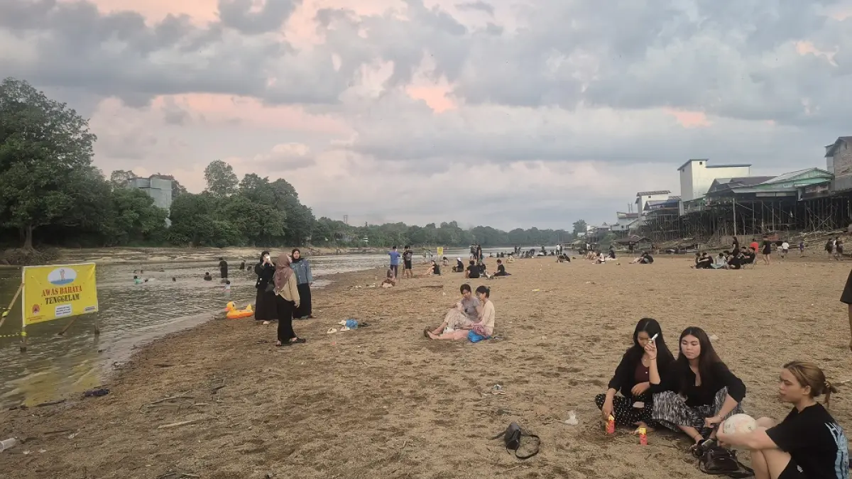 Warga di Nanga Bulik, Kabupaten Lamandau ketika menikmati hamparan pasir di Sungai Lamandau, yang muncul setiap musim kemarau, Selasa (21/7).(ria/radarsampit)