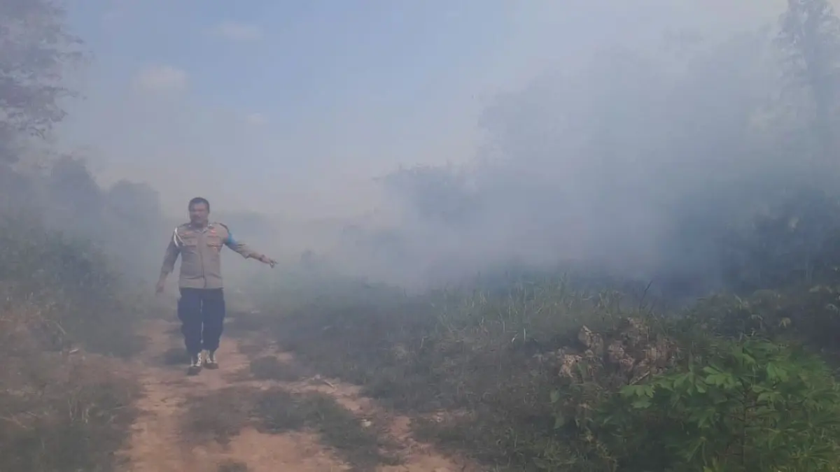 Seorang petugas kepolisian berada di sekitar lokasi kebakaran lahan di Jalan HM Arsyad, Kotawaringin Timur. (Disdamkarmat Kotim)