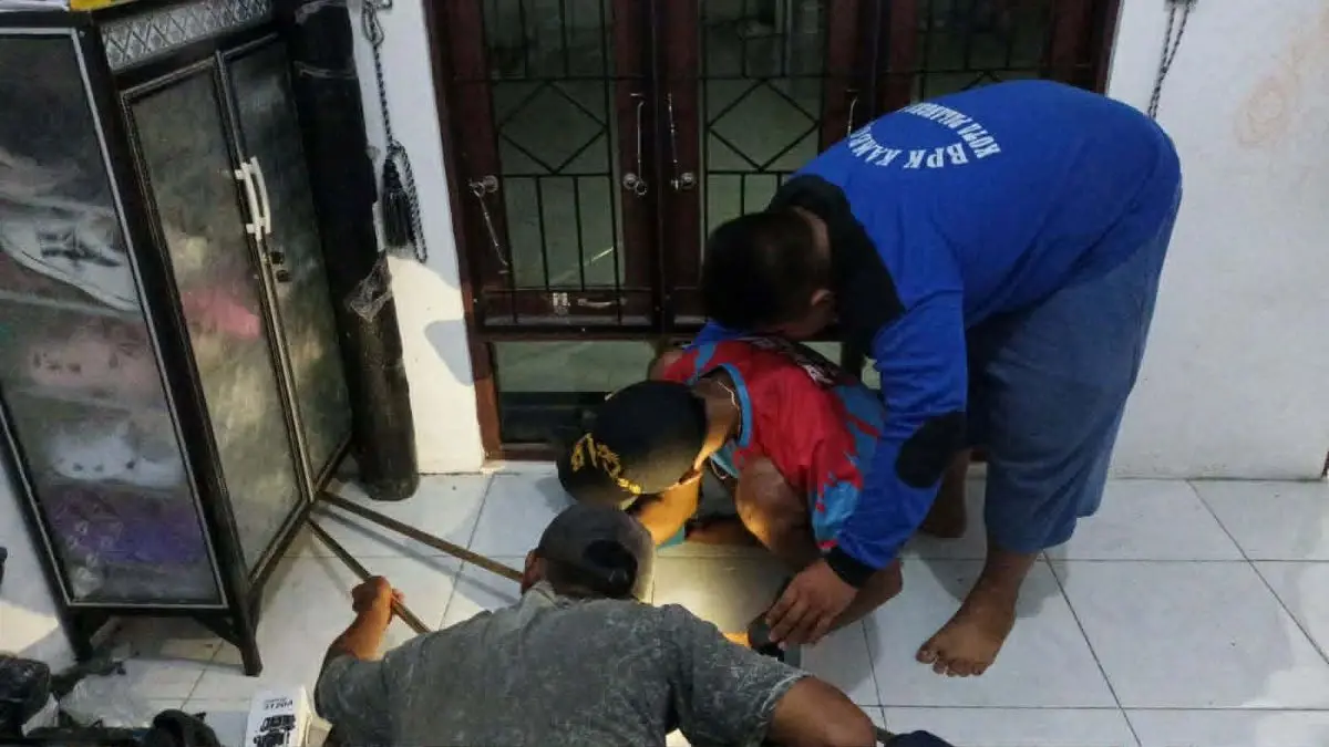EVAKUASI : Tim BPK Kamboja Palangka Raya melaksanakan evakuasi anak ular kobra dari rumah warga. FOTO: IST/RADAR SAMPIT