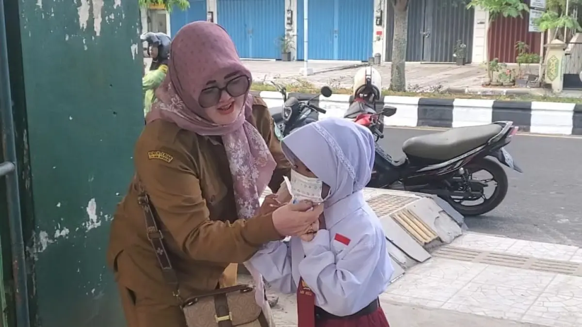 Guru SDN 6 Mentawa Baru Hulu membagikan masker kepada murid yang baru datang ke sekolah. (Usay Nor Rahmad/Radar Sampit)&nbsp;
