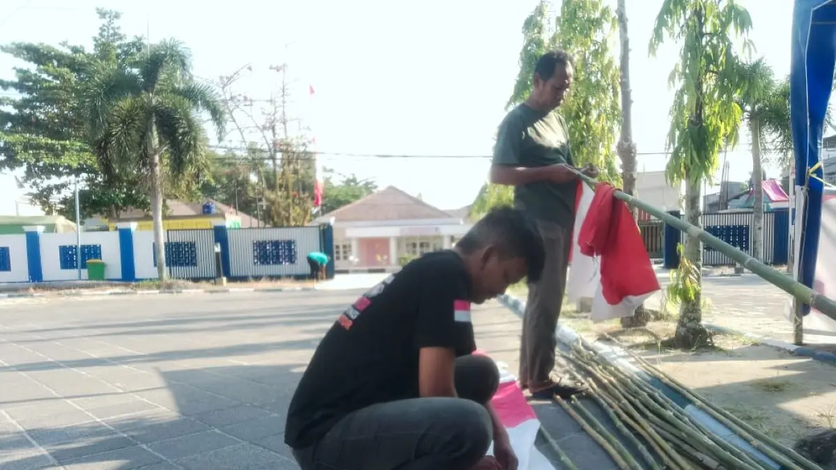 HARI KEMEDEKAAN: Komandan Satpam Radar Sampit, Taufik (berdiir) bersama anggotanya mulai menghiasi lingkungan kantor Radar Sampit dengan bendera dan umbul-umbul. FOTO: ALFIAN ARWI PERMANA/RADAR SAMPIT