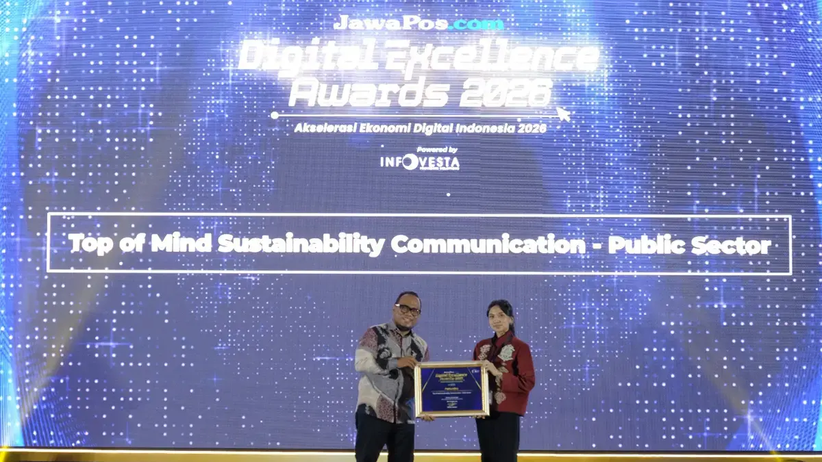 CEO JawaPos.com Dhimas Ginanjar menyerahkan penghargaan Top Sustainability Communication by Energy & Infrastructure dalam ajang Jawa Pos Digital Excellence Award 2026.  kepada Sr. Officer Media Communication PT Pertamina (Persero), Intania Prionggo di Hotel Bidakara, Jakarta Selatan, Kamis (30/7). (Istimewa/Jawapos.com)