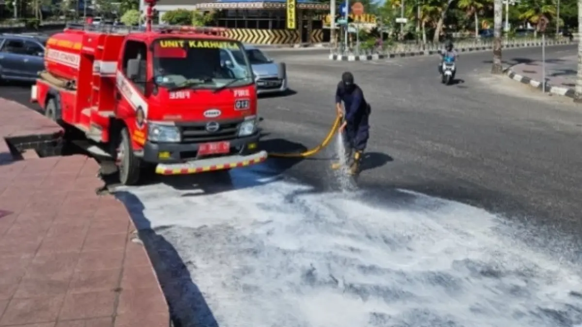 Dinas Pemadam Kebakaran dan Penyelamatan Kotawaringin Barat membersihkan ceceran solar di Jalan Iskandar, sekitar Bundaran Pancasila, Pangkalan Bun, Selasa (4/8).&nbsp;(koko/radar sampit)