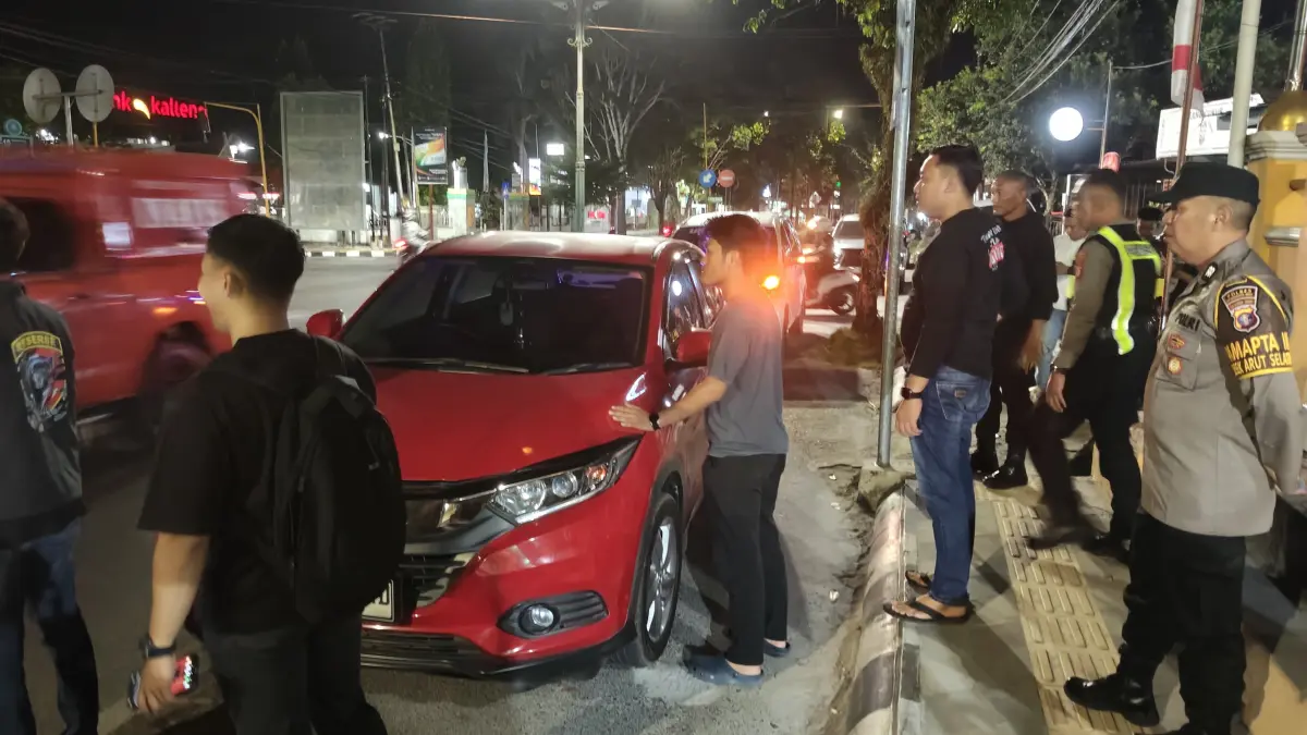 Damkar Kotawaringin Barat dan kepolisian saat berusaha membuka paksa kaca mobil HRV merah yang pengemudinya pingsan di dalam mobil, Selasa (4/8) malam. (ist)&nbsp;