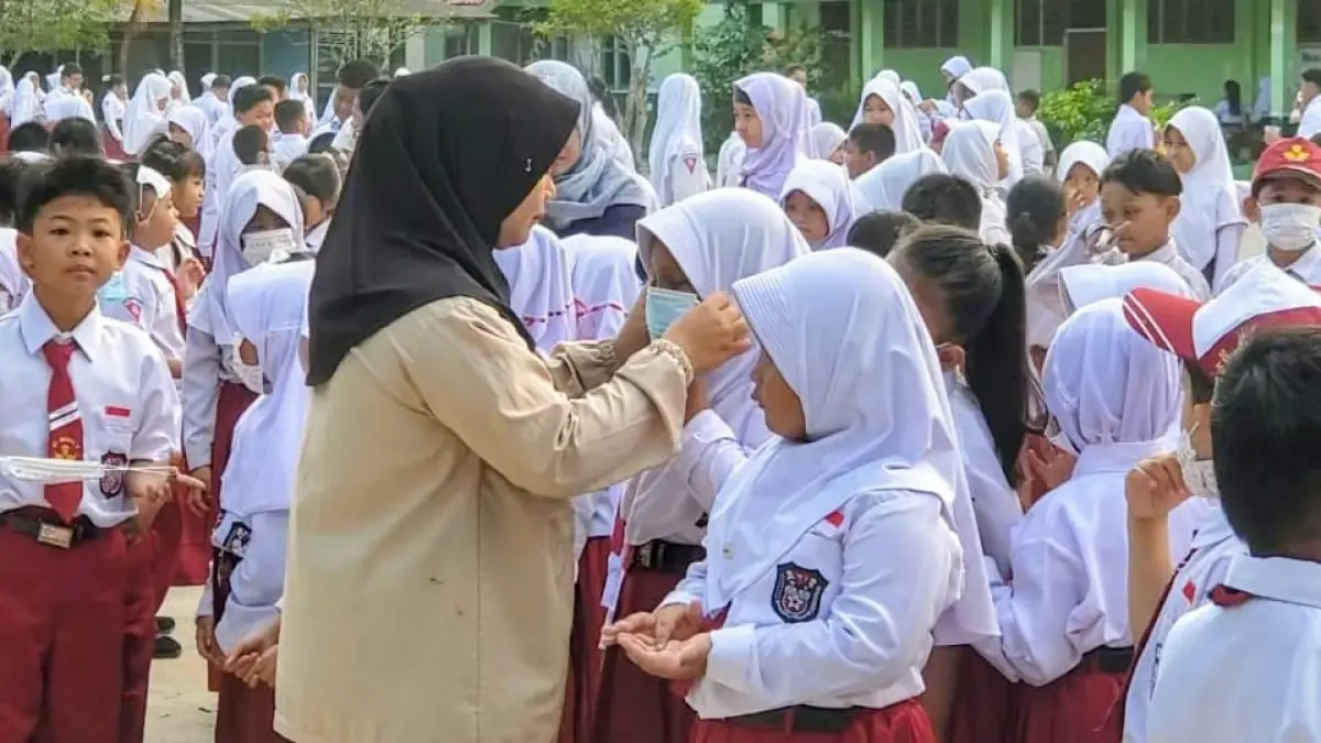 Seorang guru memakaikan masker kepada peserta didiknya untuk menghindari dampak kabut asap. (Dok. Usay Nor Rahmad/Radar Sampit)&nbsp;