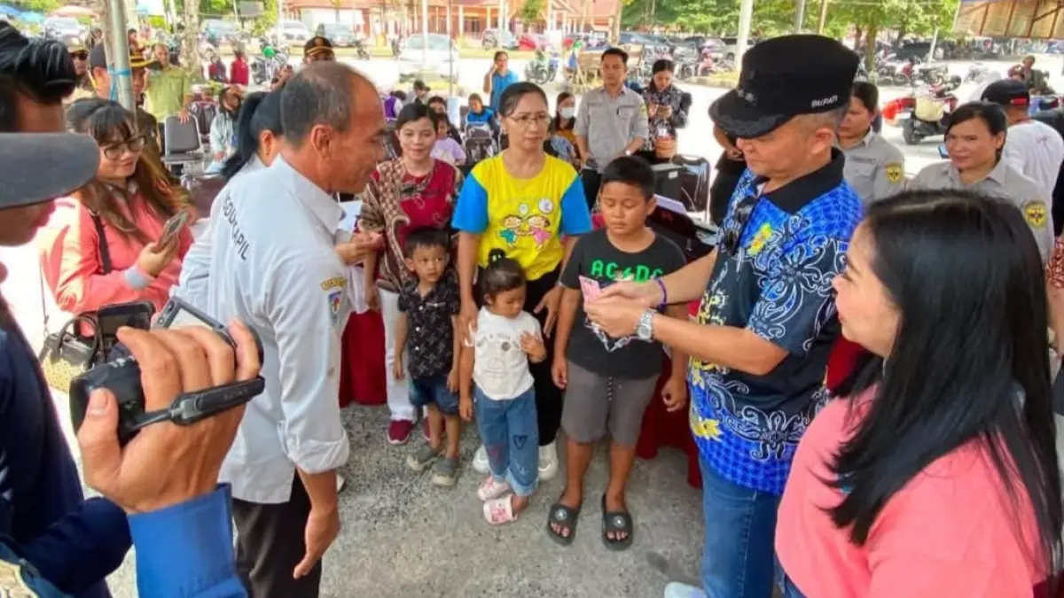 Suasana penyerahan KIA kepada anak, dalam suatu kegiatan di Taman Kota Kuala Kurun, Jumat (7/8). (DISDUKCAPIL GUNUNG MAS)