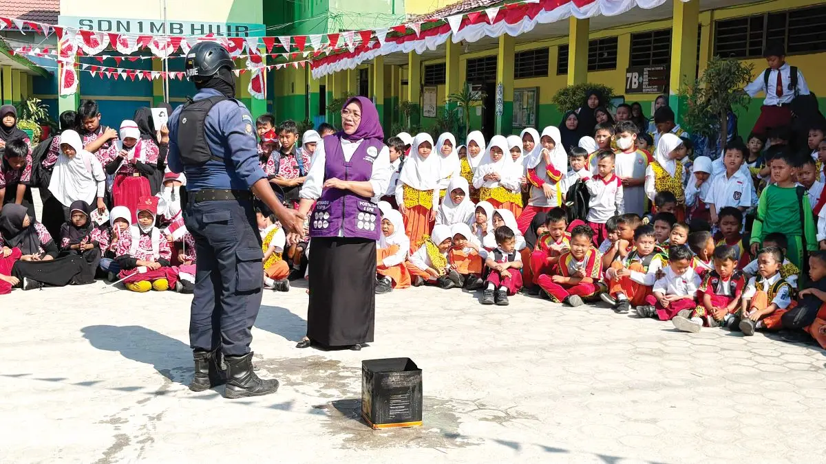 EDUKASI: Ketua TP-Posyandu Kotim Khairiah Halikinnor ikut melakukan praktik pemadaman api di depan murid SDN 1 MB Hulu, Selasa (11/8/2026). FOTO:YUNI/RADAR SAMPIT 
