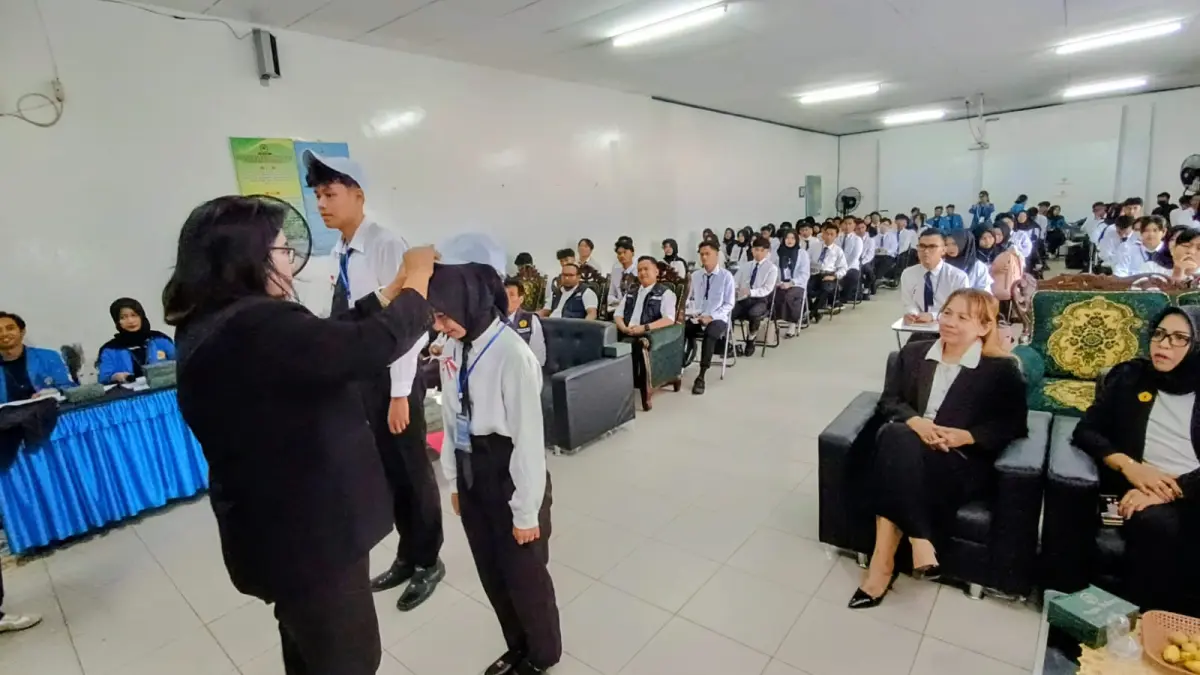 Ketua STIE Sampit Seanewati Oetama saat menyematkan atribut PKKMB kepada mahasiswa baru tanda dibukanya kegiatan orientasi pengenalan kampus, Kamis (13/8/2026). (Usay Nor Rahmad/Radar Sampit)&nbsp;