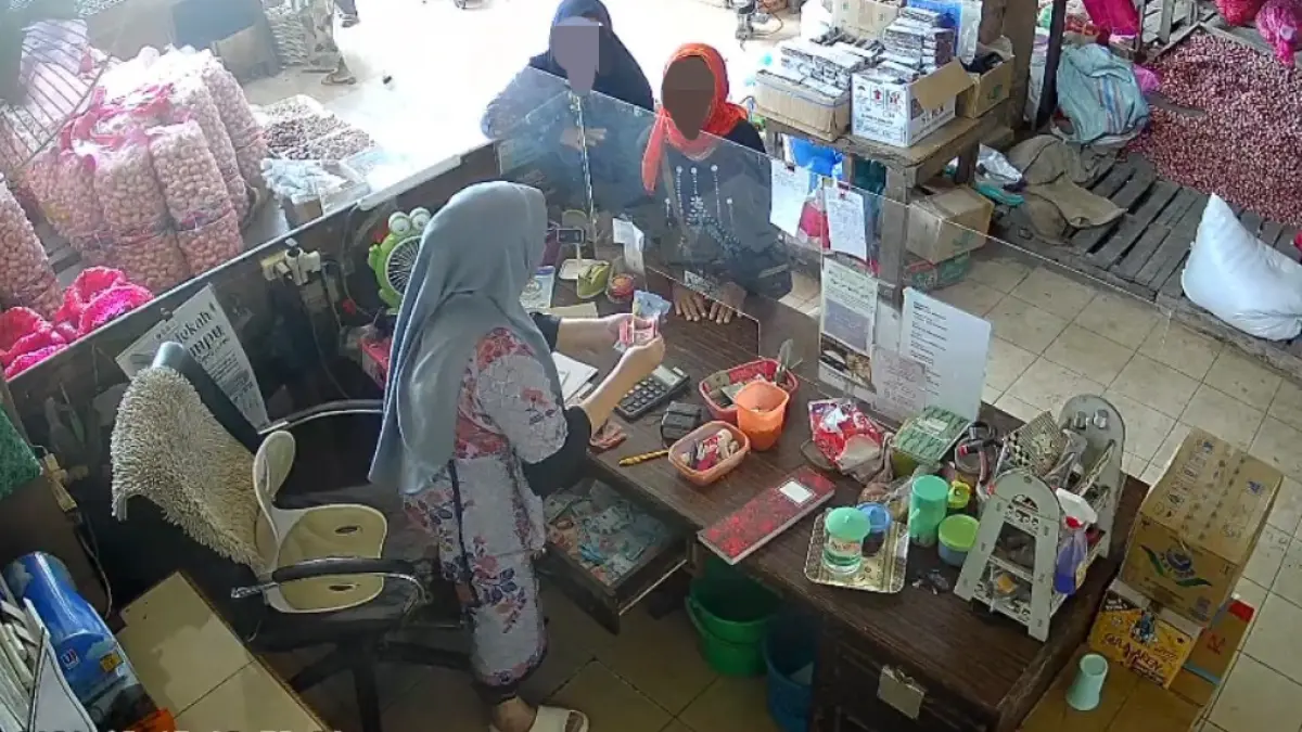 Rekaman kamera pengawas saat pemilik toko mempertanyakan uang yang digunakan untuk berbelanja oleh seorang nenek berjilbab merah di Jalan Ir Juanda Sampit, Sabtu (15/8/2026). (Warga/Radar Sampit)&nbsp;