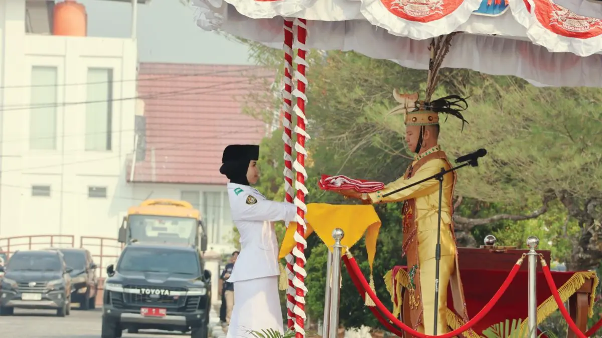 HARI KEMERDEKAAN : Bupati Gumas Jaya Samaya Monong menyerahkan bendera pusaka merah putih kepada anggota Paskibraka pembawa baki untuk dikibarkan pada upacara peringatan HUT ke-81 Kemerdekaan RI tahun 2026 tingkat Kabupaten Gumas, Senin (17/8/2026). FOTO : ARHAM SAID/RADAR SAMPIT