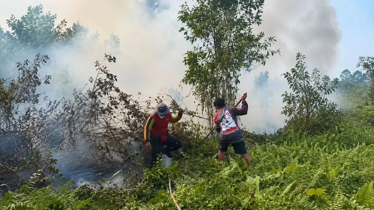 KARHUTLA: Heri salah satu warga dan relawan memadamkan api mengunakan peralatan seadanya sambil menunggu petugas Damkar datang pada Minggu (23/8/2026) sore sekitar pukul 15:30 WIB. FOTO: ALFIAN ARWI PERMANA/RADAR SAMPIT 