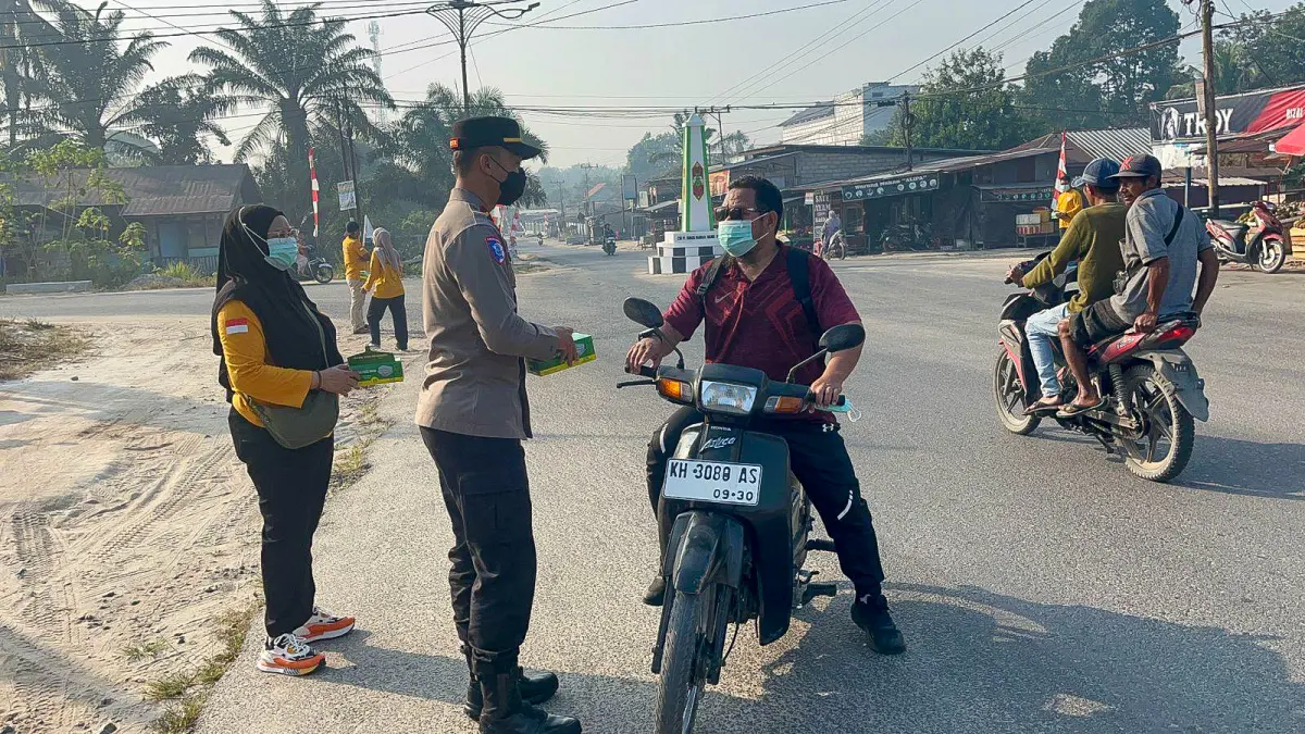 PEMBAGIAN MASKER: Polsek Hanau bersama tenaga kesehatan UPTD Puskesmas Pembuang Hulu membagikan masker kepada pengendara, Sabtu (29/8/2026). (Rifani/Radar Sampit)