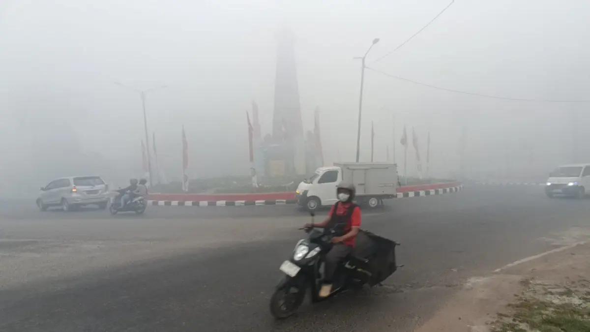 Sejumlah pengendara menerobos pekatnya asap, tampak bundaran 0 Kilometer Sampit juga tertutup dengan jarak pandang yang terbatas, Senin (31/8/2026). (Usay Nor Rahmad/Radar Sampit)
