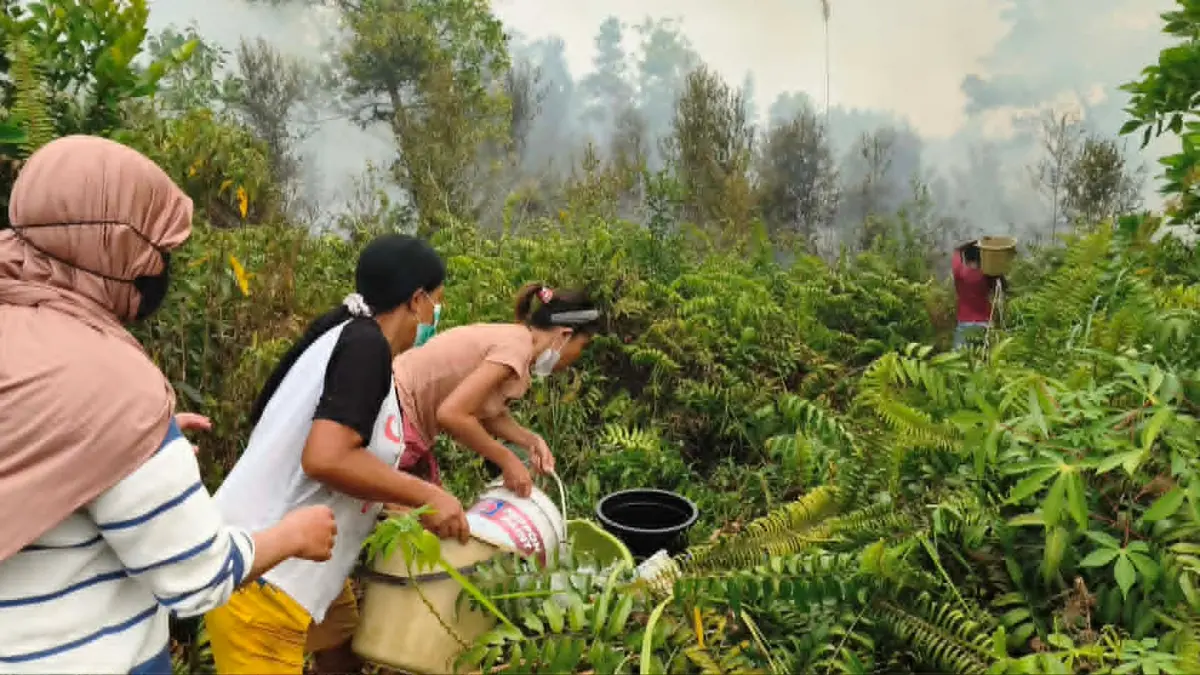 Warga di permukiman di Jalan Pasendang Ujung, Palangka Raya bahu membahu dengan peralatan seadanya, menuangkan air untuk memadamkan kebakaran lahan yang semakin mendekati rumah mereka, Rabu (2/9). (dodi/radarsampit)