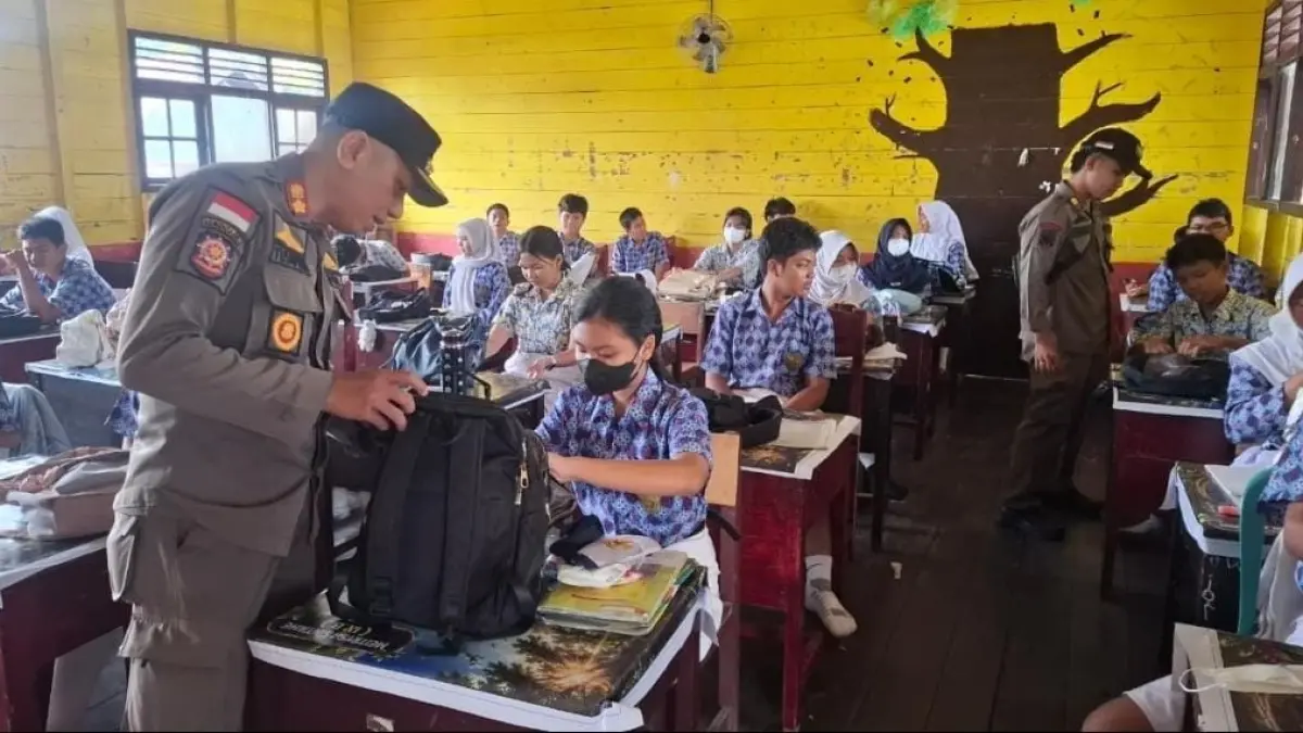 Personel Satuan Polisi Pamong Praja (Satpol PP) Kabupaten Lamandau menggelar razia barang bawaan pelajar SMP Negeri 4 Bulik, Kamis (3/9). (Ria/Radar Sampit)&nbsp;