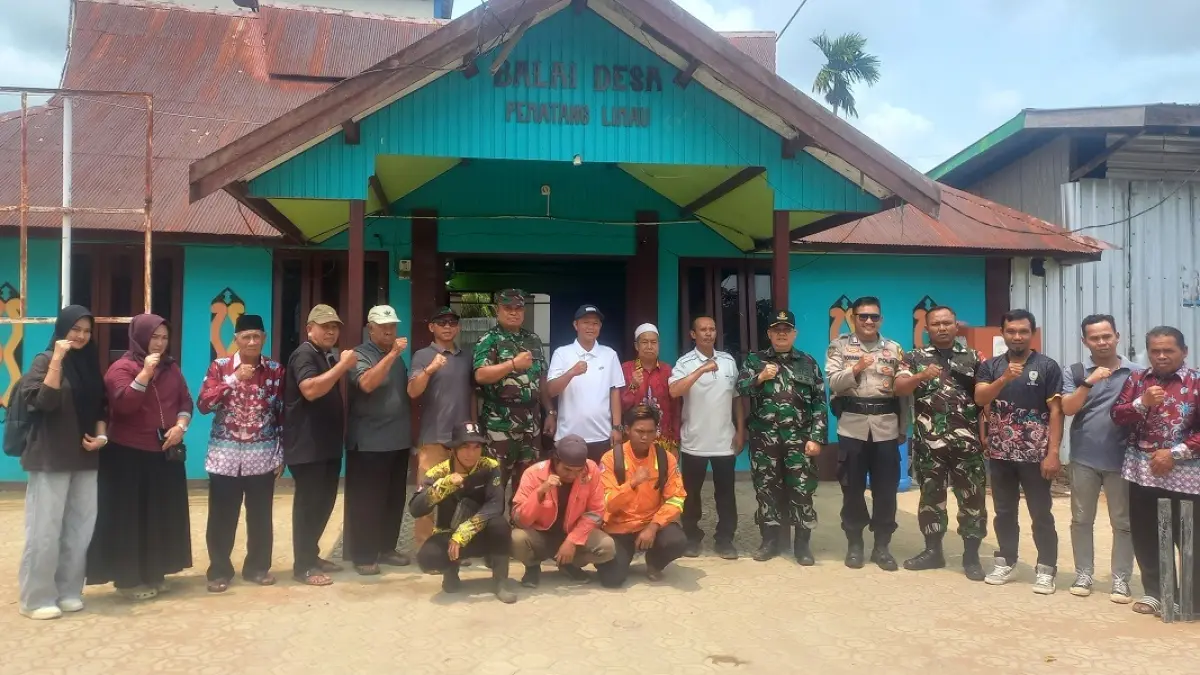 Tim Satgas Penyuluhan Mabes TNI berfoto bersama di depan Balai Desa Pematang Limau, Kecamatan Seruyan Hilir, Jumat (4/9). (Rifani/Radar Sampit) 