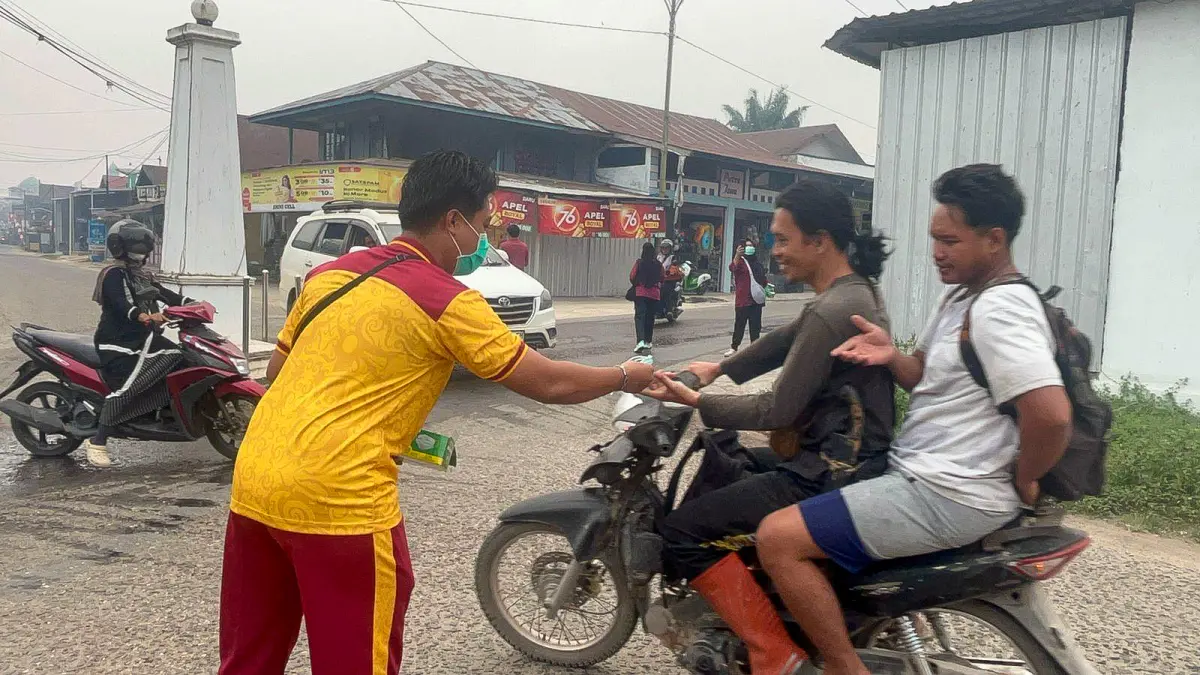 BAGIKAN MASKER: Polsek Hanau, Koramil 1015-11, dan UPTD Puskesmas Pembuang Hulu membagikan masker kepada warga di Simpang 4 Bundaran Ban Pembuang Hulu I, Sabtu (5/9/2026).