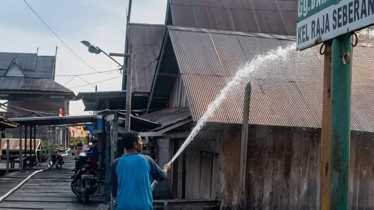 Salah seorang anggota MPA Raja Seberang, saat mengguyurkan air ke atap rumah warga di Kelurahan Raja Seberang, Kecamatan Arsel, Kabupaten Kotawaringin Barat, Sabtu 5 September 2026.&nbsp;(ist) 