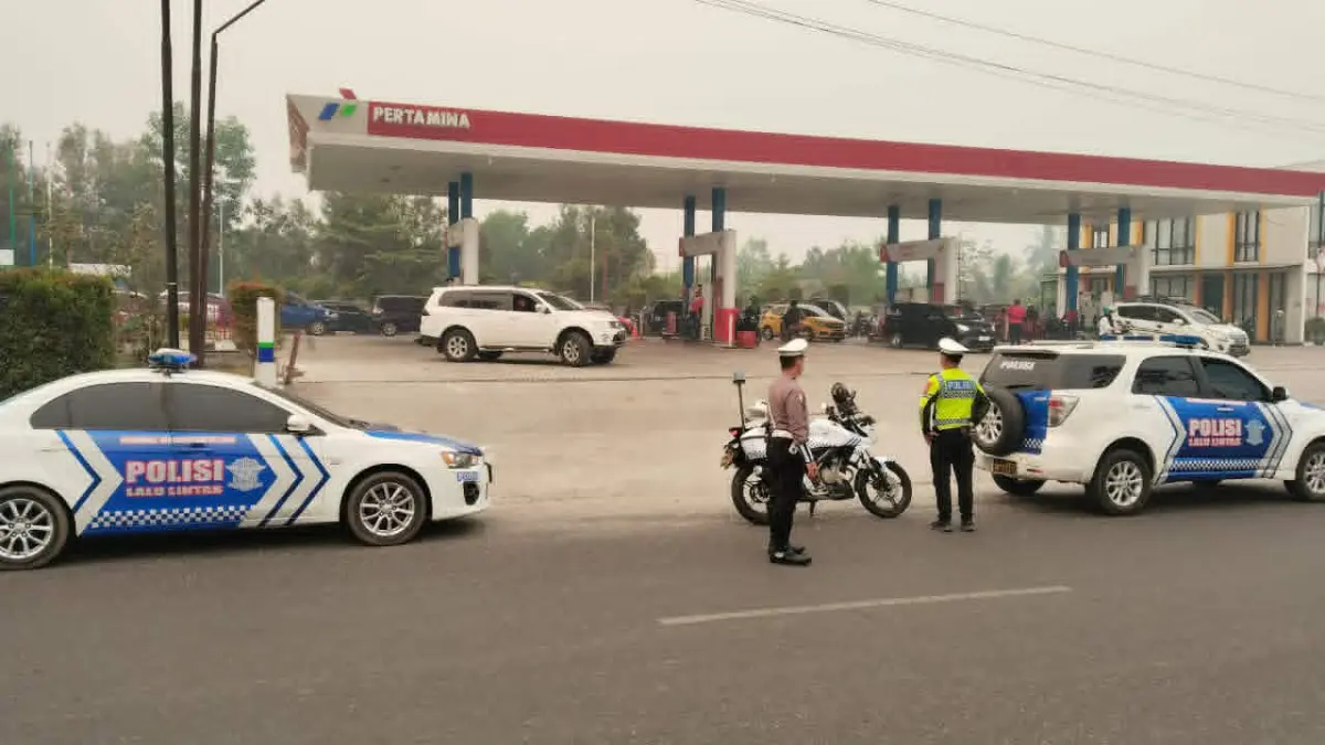 Petugas Sat Lantas Polresta Palangka Raya saat mengatur lalu lintas disalah satu SPBU di Palangka Raya,  karena antrean panjang kendaraan mengisi BBM.(dodi/radarsampit)