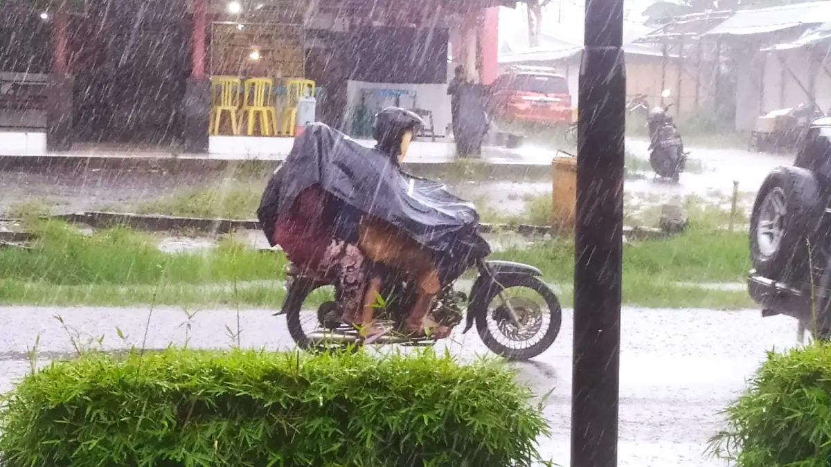 HUJAN: Pengendara sepeda motor menggunakan mantel menerobos derasnya hujan. (Usay Nor Rahmad/Radar Sampit)