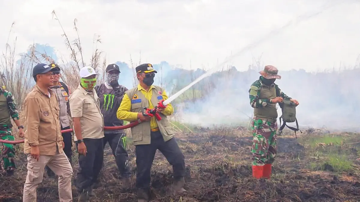 PADAMKAN API: Bupati Seruyan Ahmad Selanorwanda membantu memadamkan api di sekitar akses jalan menuju Desa Tanjung Rangas. Kamis (17/9/2026). FOTO: DISKOMINFOSANDI SERUYAN/RADAR SAMPIT