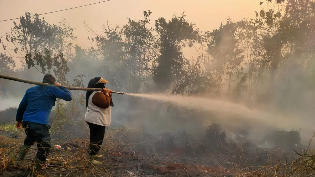 PEMADAMAN: Wabup Kotim Irawati turut membantu petugas melakukan pemadaman pada lahan terbakar di Jalan Tjilik riwut km 7-8 arah Kotabesi, Sabtu (19/9). (YUNI/RADAR SAMPIT)