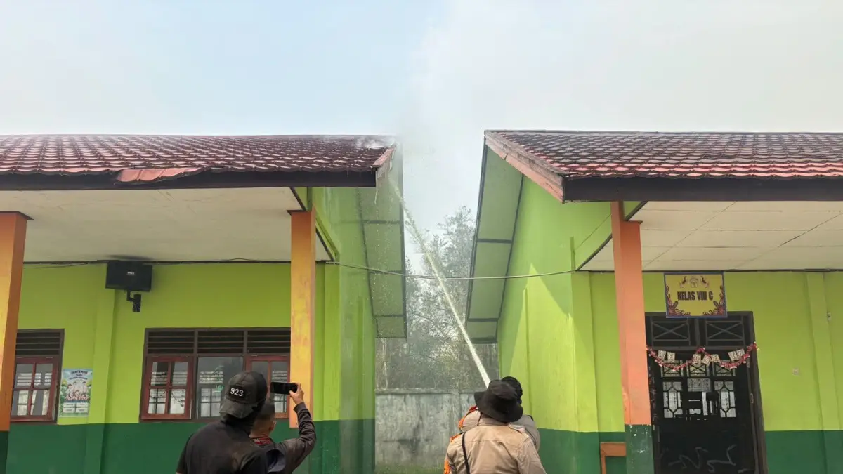 Bangunan milik SMP Negeri 8 terbakar akibat rembetan api dari kebakaran lahan di samping sekolah, Selasa (22/9/2026). (Satgas Karhutla)