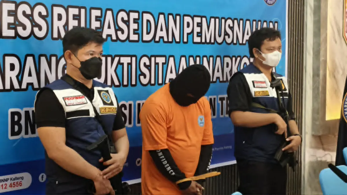SR, yang merupakan residivis kasus peredaran narkoba dan kembali ditangkap pihak BNNP ketika diapit dua petugas dalam rilis kasusnya, Kamis (24/9).(dodi/radarsampit)