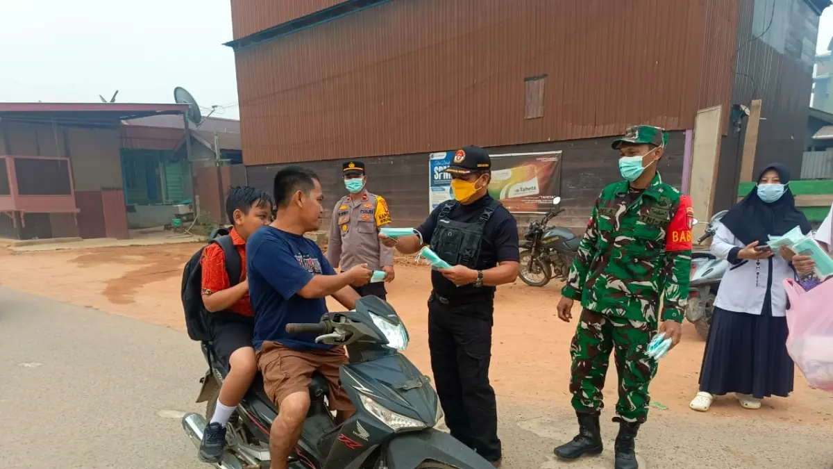 Polsek Seruyan Hulu bersama Puskesmas dan Pemerintah Kecamatan Seruyan Hulu membagikan masker kepada warga Desa Tumbang Manjul, Kamis (24/9). &nbsp;(Rifani/Radar Sampit)