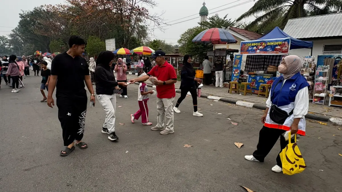 PEDULI: Warga menerima masker yang dibagikan Hiswana Migas dalam kegiatan CFD di Taman Kota Sampit, Minggu (27/9).YUNI/RADAR SAMPIT