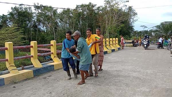 PICU KECELAKAAN: Salah seorang pengendara yang terjatuh di jembatan Dusun Karang Anyar ditolong warga, baru-baru ini. (ISTIMEWA/RADAR PANGKALAN BUN)