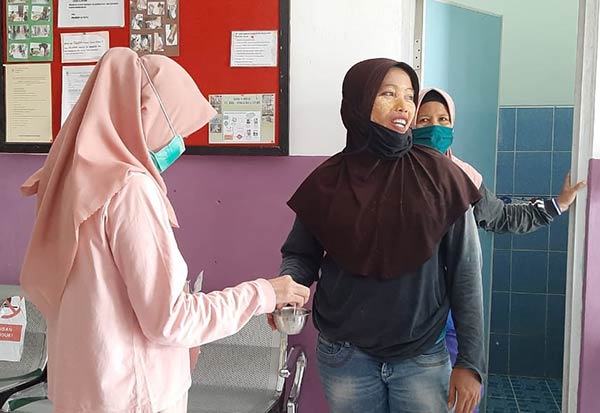 LAYANAN KESEHATAN: Petugas Polibun saat mengecek sampel urine seorang pekerja perempuan bagian semprot chemist agar kehamilan bisa terdeteksi lebih awal, sehingga pekerja lebih aman dari paparan zat kimia.