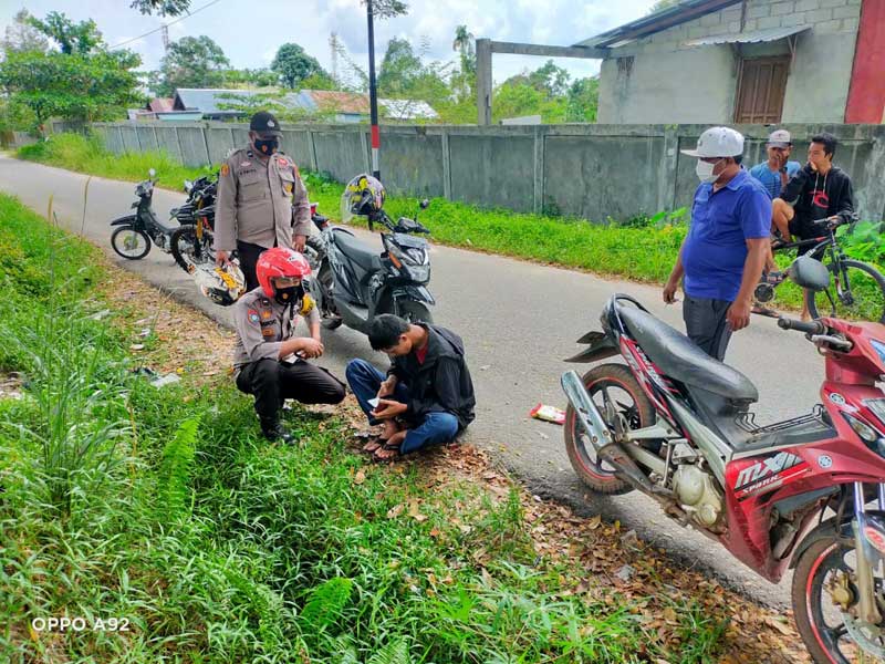 PEMABUK : Petugas Polsek Baamang mendatangi pemuda yang tergeletak di pinggir jalan lantaran mabuk berat, Selasa (4/1) sore. IST/RADAR SAMPIT