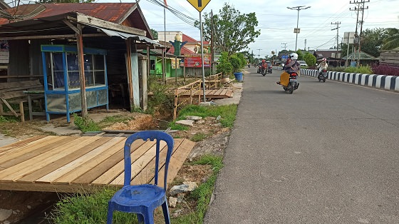 PROYEK GAGAL: Jembatan kayu sementara dibuat untuk membantu akses warga yang terganggu akibat gagalnya proyek pembangunan drainase. (RIA MEKAR/RADAR SAMPIT)