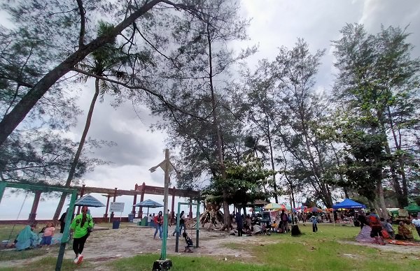 RAMAI PENGUNJUNG: Suasana Pantai Kubu, Kecamatan Kumai, Kabupaten Kotawaringin Barat, ramai dipadai pengunjung, Minggu (2/1) (SULISTYO/RADAR PANGKALAN BUN)