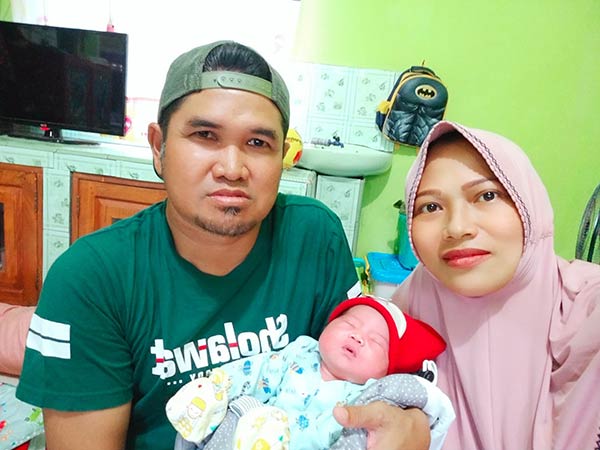 SEHAT: Sukardi, Kades Bajarau, dan istrinya, Nurul Husnah bersama buah hati yang lahir di ambulans. (SUKARDI FOR RADAR SAMPIT)