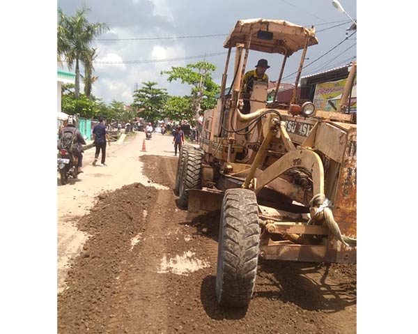 DIPERBAIKI: Petugas teknis di Dinas PUPRKP Kotim memperbaiki jalan sekitar Pasar Sajumput, Jalan DI Panjaitan, Senin (11/4). (HENY/RADAR SAMPIT)