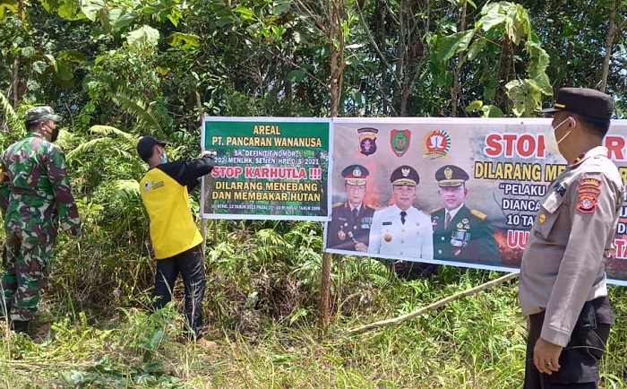 TANDA WILAYAH: Petugas perusahaan sedang memasang tanda wilayah PT PWN dengan pengawasan aparat TNI dan Polri (istimewa/radar sampit)