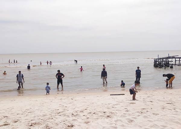 WISATA PANTAI: Sejumlah pengunjung saat bermain dan mandi di Pantai Anugerah yang ada di Desa Sungai Tabuk. (FAUZIANUR/RADAR SAMPIT)