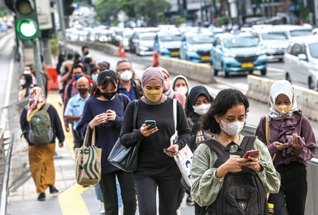Ilustrasi. Pekerja melintas di kawasan Sudirman, Jakarta. (MIFTAHULHAYAT/JAWA POS)