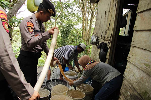 BANTUAN: Personel Polres Gumas saat melakukan pendistribusian air bersih kepada warga di perbukitan, Rabu (26/4). (HUMAS POLRES GUNUNG MAS FOR RADAR SAMPIT)