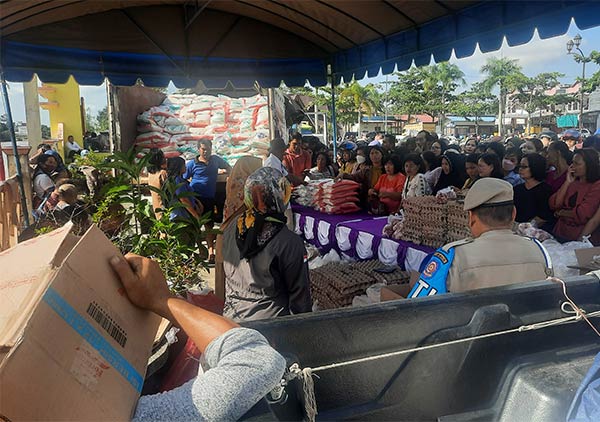 TERTIB: Ratusan masyarakat mengantri untuk mendapatkan bahan pokok murah, saat pelaksanaan operasi pasar pangan murah, di Taman Kota Kuala Kurun, Selasa (16/5). (ARHAM SAID/RADAR SAMPIT)