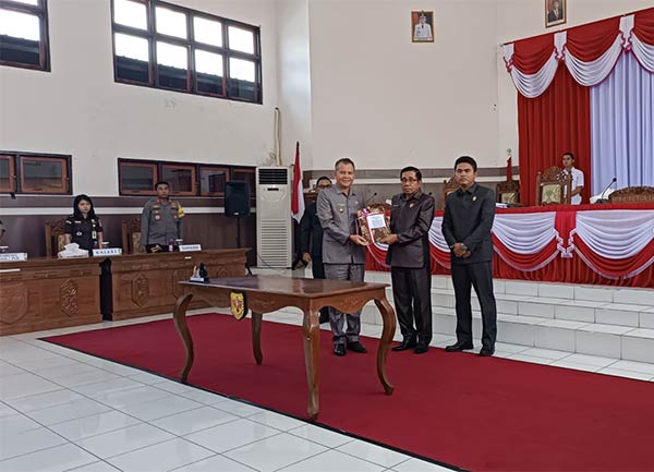 RESMI: Bupati Gumas Jaya Samaya Monong menerima dokumen persetujuan bersama terhadap enam buah raperda, dari Ketua DPRD Gumas Akerman Sahidar,  Selasa (11/7). (ARHAM SAID/RADAR SAMPIT)