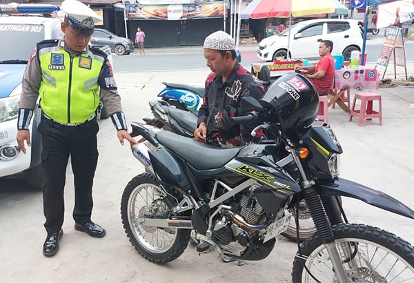 TINDAKAN: Personel Polantas Polres Katingan ketika memberikan sanksi keras penggunaan kendaraan dengan knalpot brong di kawasan Jalan Tjilik Riwut, Rabu (16/8). (ISTIMEWA/RADAR SAMPIT)
