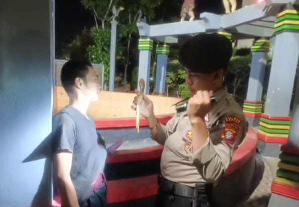DIAMANKAN: Anggota Polres Kapuas  saat menemukan senjata tajam dari tangan  seorang pria yang sedang duduk di taman kota Kapuas. (ISTIMEWA/SATSAMAPTA POLRES KAPUAS)