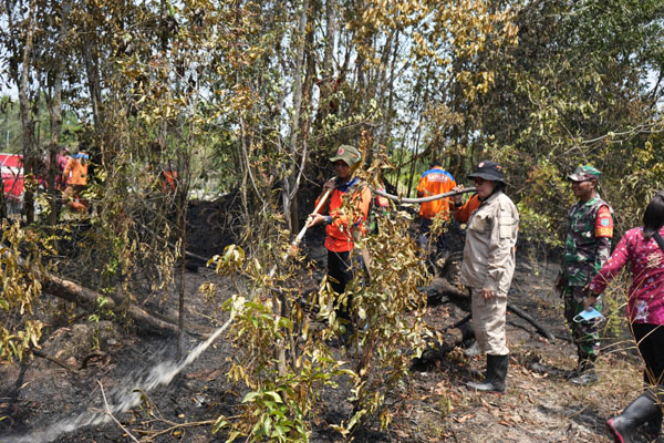 KARHUTLA: Pj Bupati Lamandau Lilis Suriani didampingi Kepala BPBD Lamandau Hendikel meninjau lokasi kebakaran hutan dan lahan di Kecamatan Bulik, Senin (2/10). (ISTIMEWA/RADAR SAMPIT)