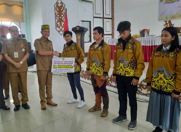 APRESIASI: Bupati Gumas Jaya Samaya Monong saat menyerahkan secara simbolis uang bonus kepada atlet peraih medali dan uang saku kontingen Porprov XII Kalteng, di GPU Damang Batu, Selasa (5/12). (ARHAM SAID/RADAR SAMPIT)