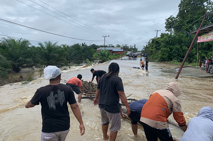 MELUAP: Hujan yang mengguyur sejak Jumat (15/3) subuh menyebabkan satu ruas jalan di Talisayan terdampak banjir yang menghambat kegiatan masyarakat.