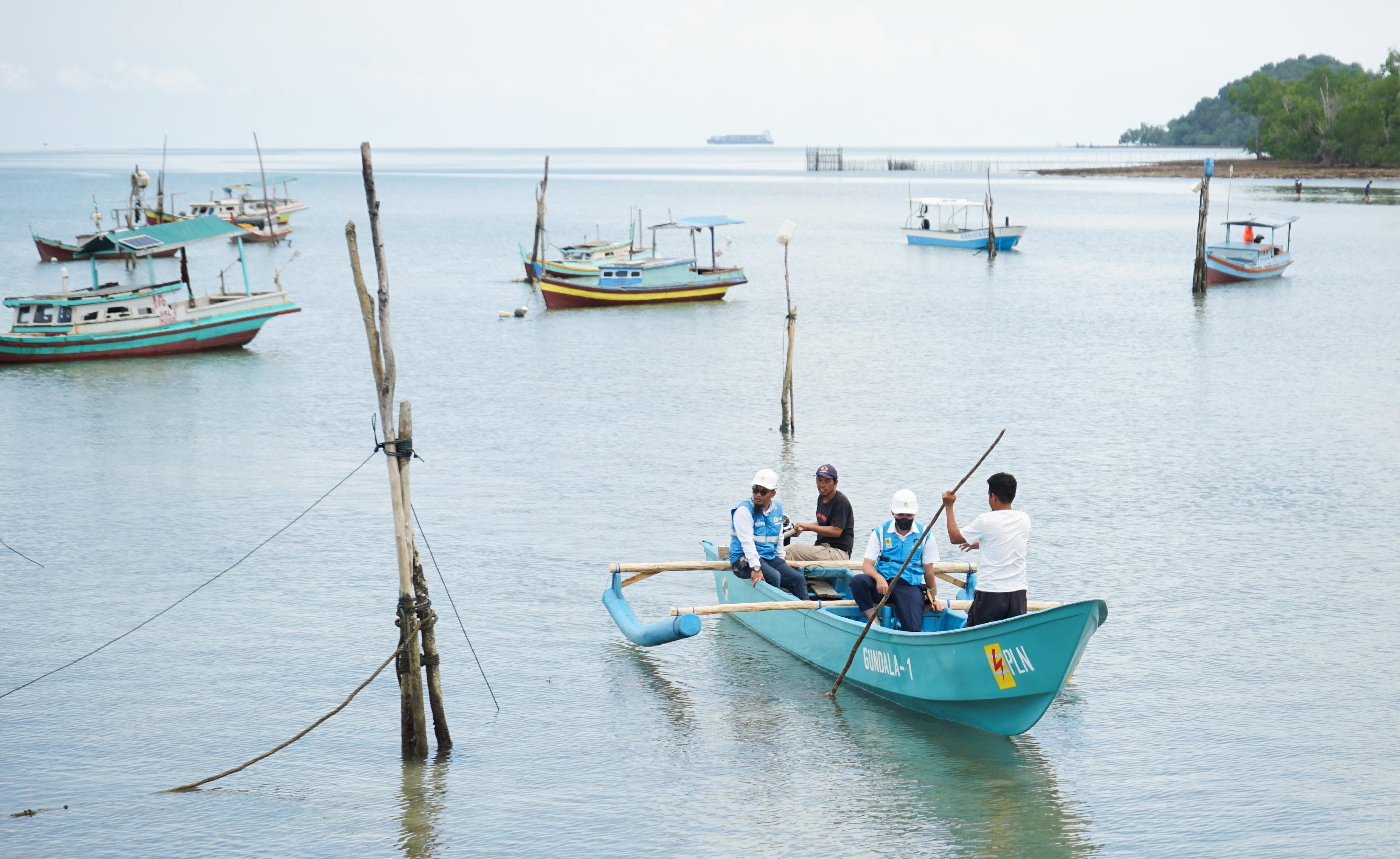 Petugas PLN melakukan uji coba bantuan mesin perahu listrik di dermaga pelabuhan nelayan Desa Suak Gual. Dengan bantuan mesin perahu listrik tersebut, para nelayan kini dapat melaut tanpa menimbulkan